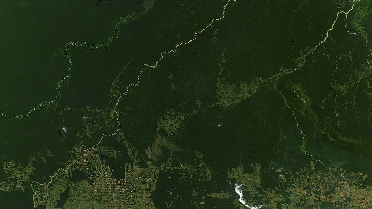 Stand-in, not a photo of this event: NASA satellite view of the Brazilian Amazon on July 23, 2026, dark green forest crossed by winding tan rivers, with checkerboard patches of cleared land along the bottom edge