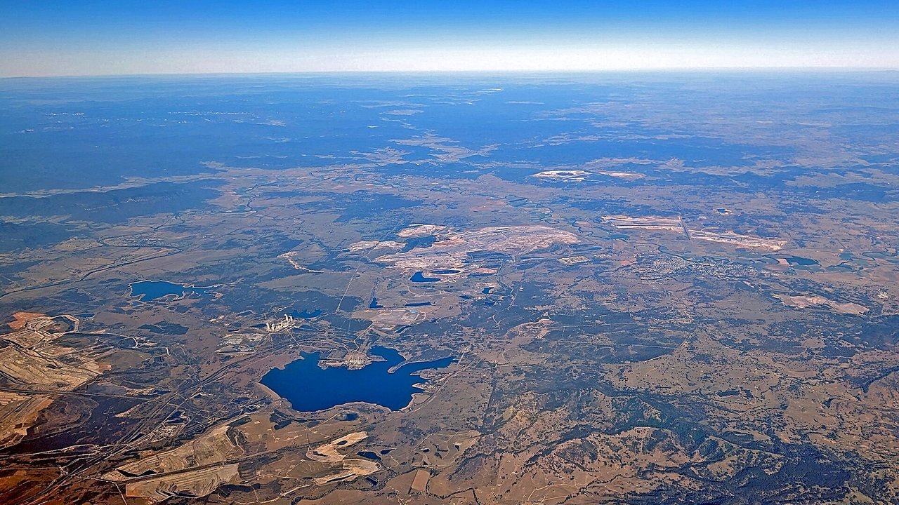 Stand-in: February 2024 aerial file photo of open-cut coal operations in the Hunter Valley near Muswellbrook, New South Wales, with Lake Liddell and the closed Liddell Power Station, not a photo of the Mount Pleasant mine, the court, or the ruling