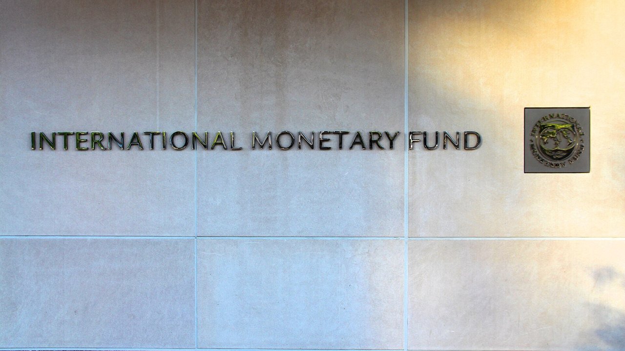 Stand-in, not a photo of this event: a June 2013 file photo of the words International Monetary Fund in metal letters on a pale stone wall beside the IMF seal at the fund’s Washington headquarters