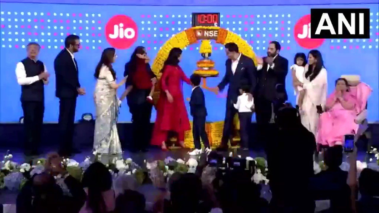 Video still posted on X by @EconomicTimes: members of the Ambani family and National Stock Exchange officials stand on a stage in Mumbai around a ceremonial gong, under a large Jio and NSE screen with a clock reading 10:00, at the Jio Platforms listing ceremony, according to the post; an ANI watermark appears at top right