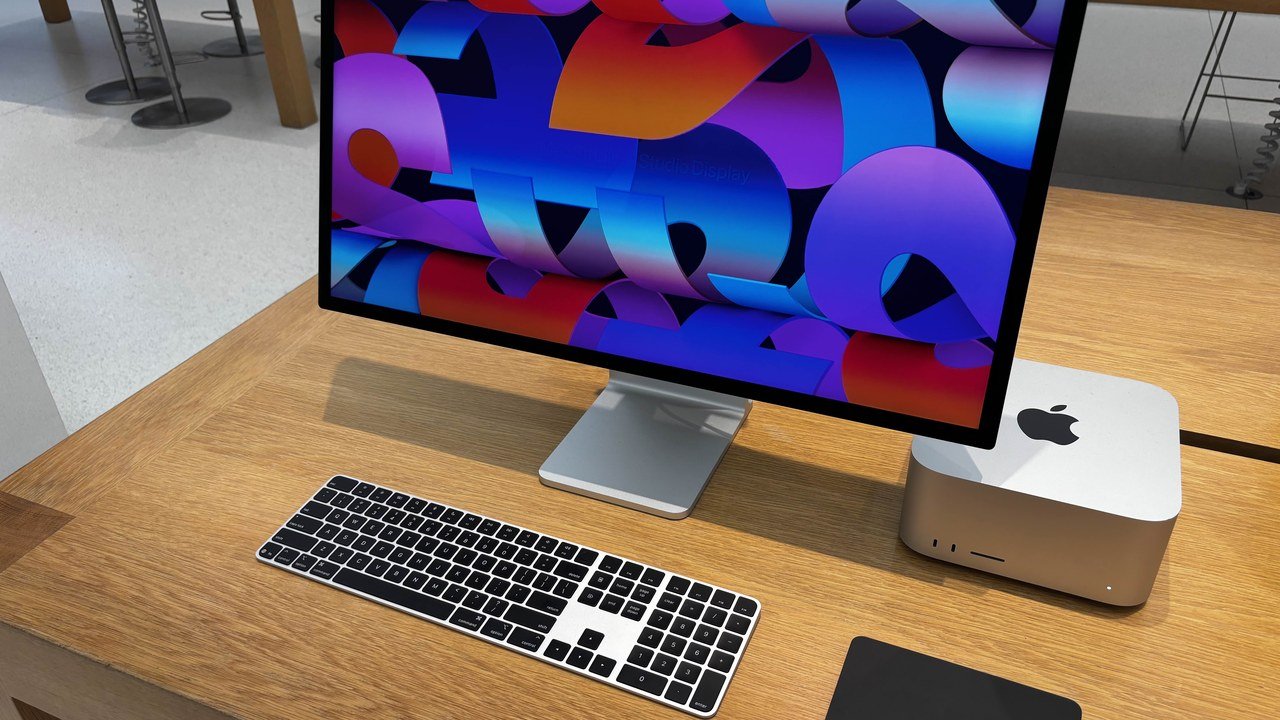 Stand-in, not a photo of this event: an Apple Studio Display and Mac Studio with Magic Keyboard and Magic Trackpad on a store demo table, photographed in December 2025
