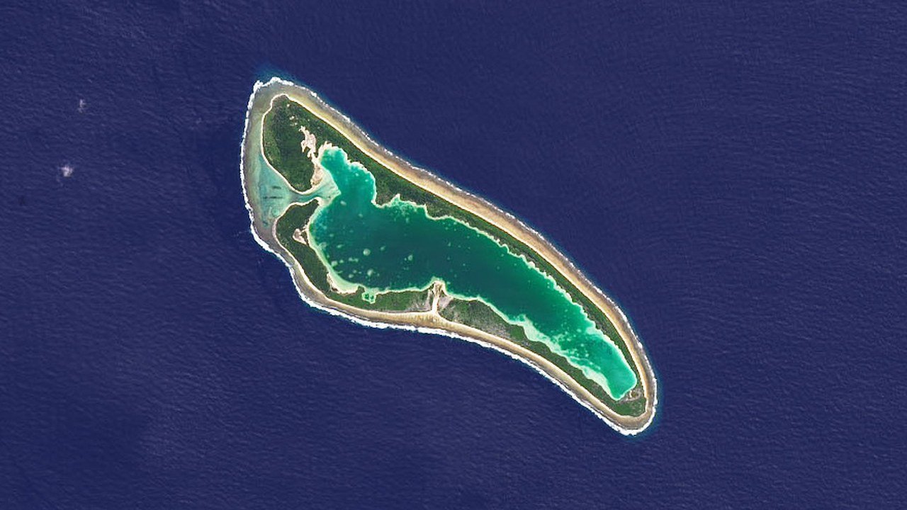 Stand-in, not a photo of this event: July 2014 NASA Landsat 8 satellite view of Nikumaroro atoll, a narrow ring of sand and green vegetation around a turquoise lagoon in dark blue ocean