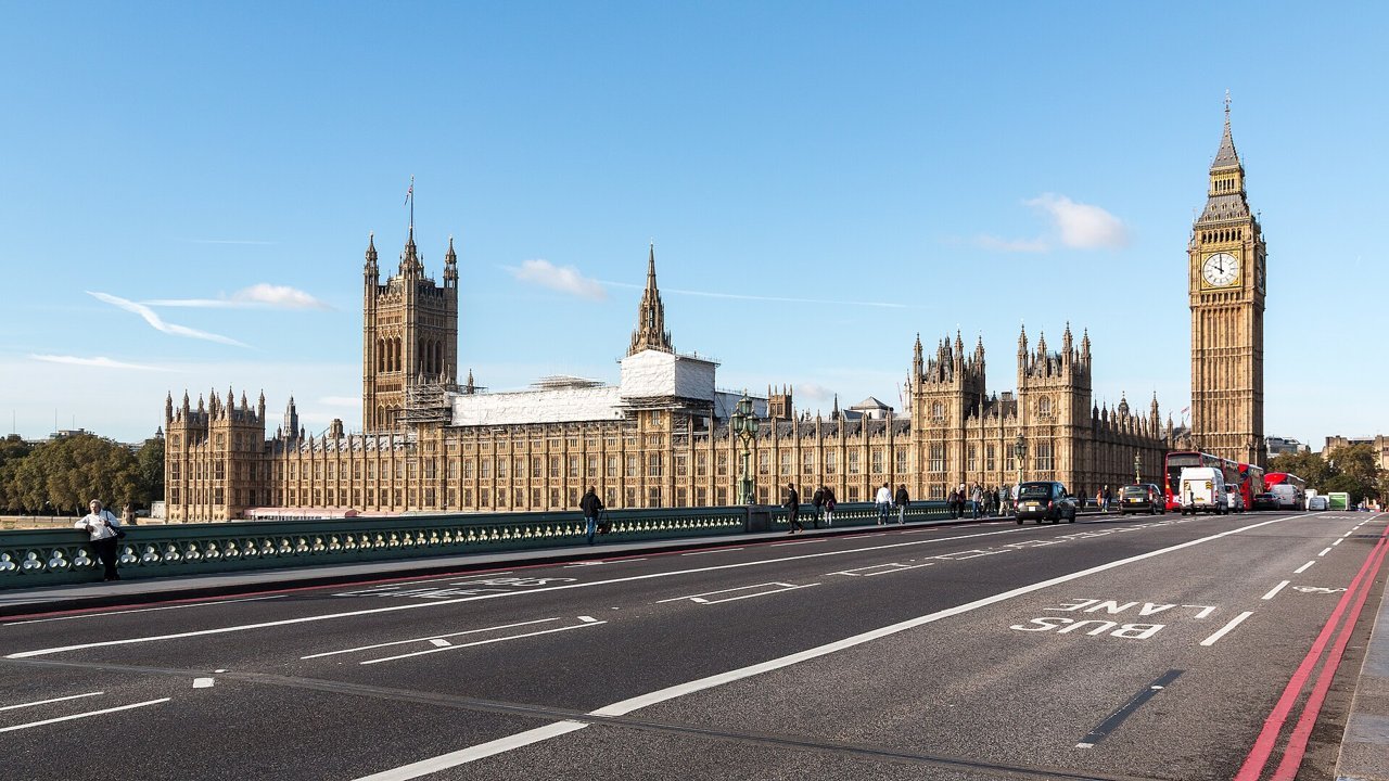 Stand-in, not a photo of this event: an October 2016 file photo of the Palace of Westminster and Elizabeth Tower in London, seen from Westminster Bridge under a blue sky, with a few distant pedestrians and traffic