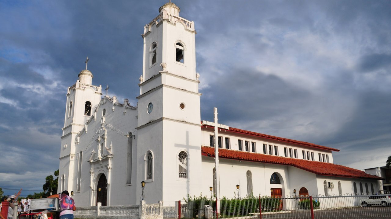 Stand-in, not a photo of this event: a November 2011 file photo of the twin-towered San Juan Bautista Cathedral in Penonomé, Panama, under a cloudy sky, years before the quake