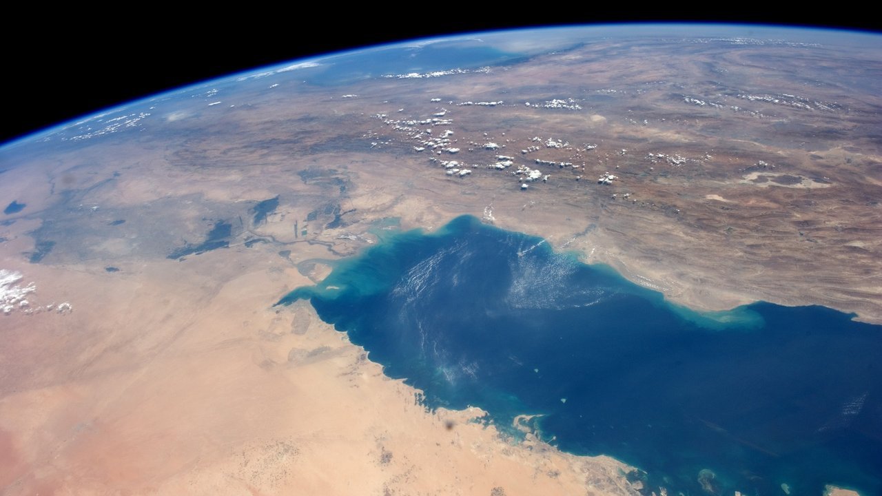 Stand-in, not a photo of this event: the deep blue Persian Gulf curving between the deserts of Arabia and the mountains of Iran under Earth’s horizon, in an Aug. 25, 2014 NASA photo from the International Space Station