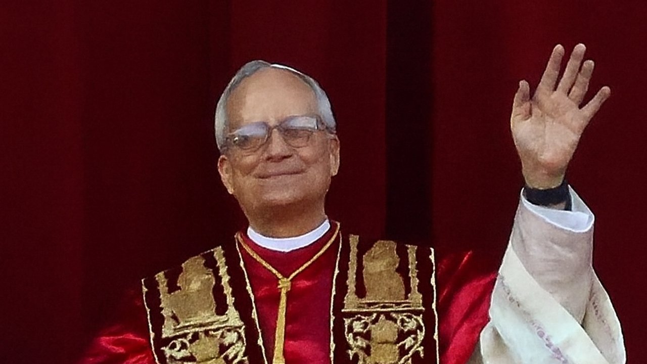 File photo, not from this week: Pope Leo XIV, in a red mozzetta and gold-embroidered stole, smiles and waves from the loggia of St. Peter’s Basilica after his election on May 8, 2025