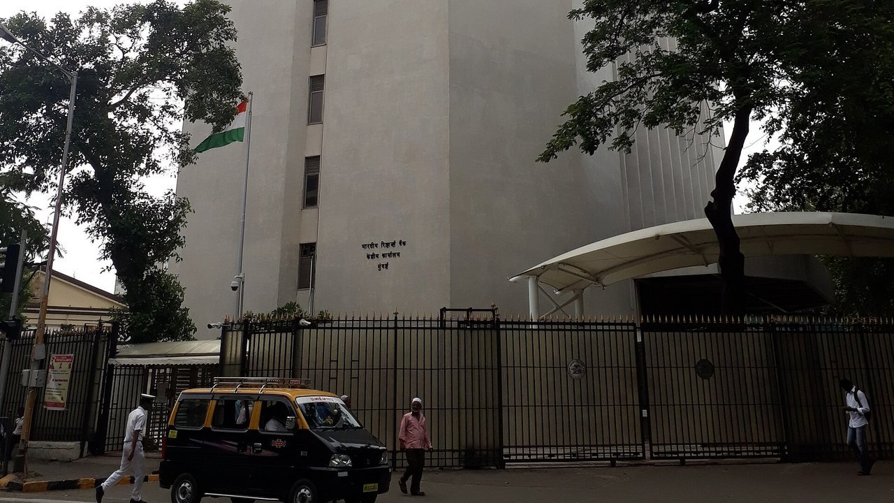 Stand-in: June 2018 file photo of the Reserve Bank of India central office tower and gate in Mumbai, with a taxi passing, not a photo of Wednesday’s policy meeting or announcement