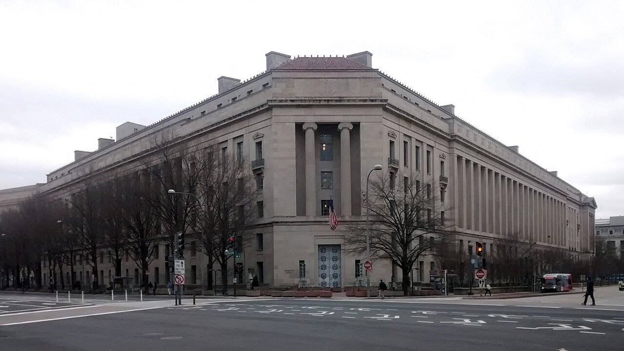 Stand-in, not a photo of this event: an April 2014 file photo of the Robert F. Kennedy Department of Justice Building in Washington, DC, under an overcast sky, with bare trees and a quiet intersection in front
