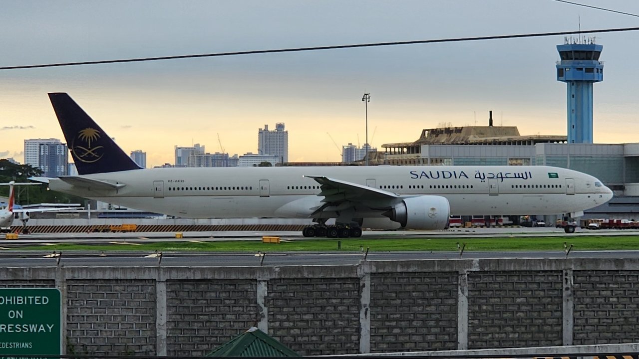 Archival stand-in: an undamaged Saudia Boeing 777, registration HZ-AK29, taxis at Manila’s airport in June 2024, not the plane in this story