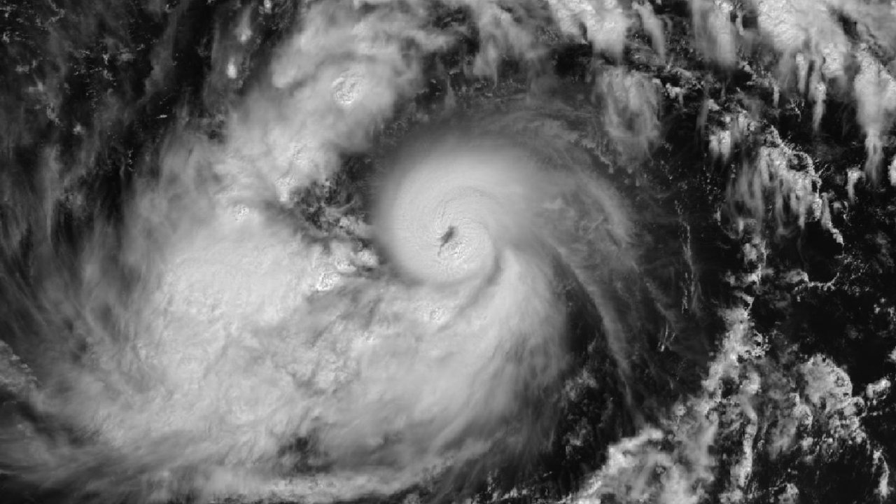 Black-and-white satellite view of Typhoon Champi on October 17, 2026, 10:45 AM ChST, with a distinct eye inside a dense, round cloud mass and curved rain bands