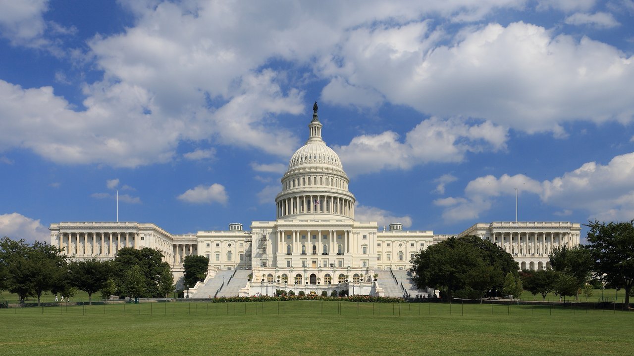 Stand-in, not a photo of this event: a September 2013 file photo of the west front of the United States Capitol in Washington, DC, with its white dome and wings behind trees and a wide lawn under a blue sky with white clouds